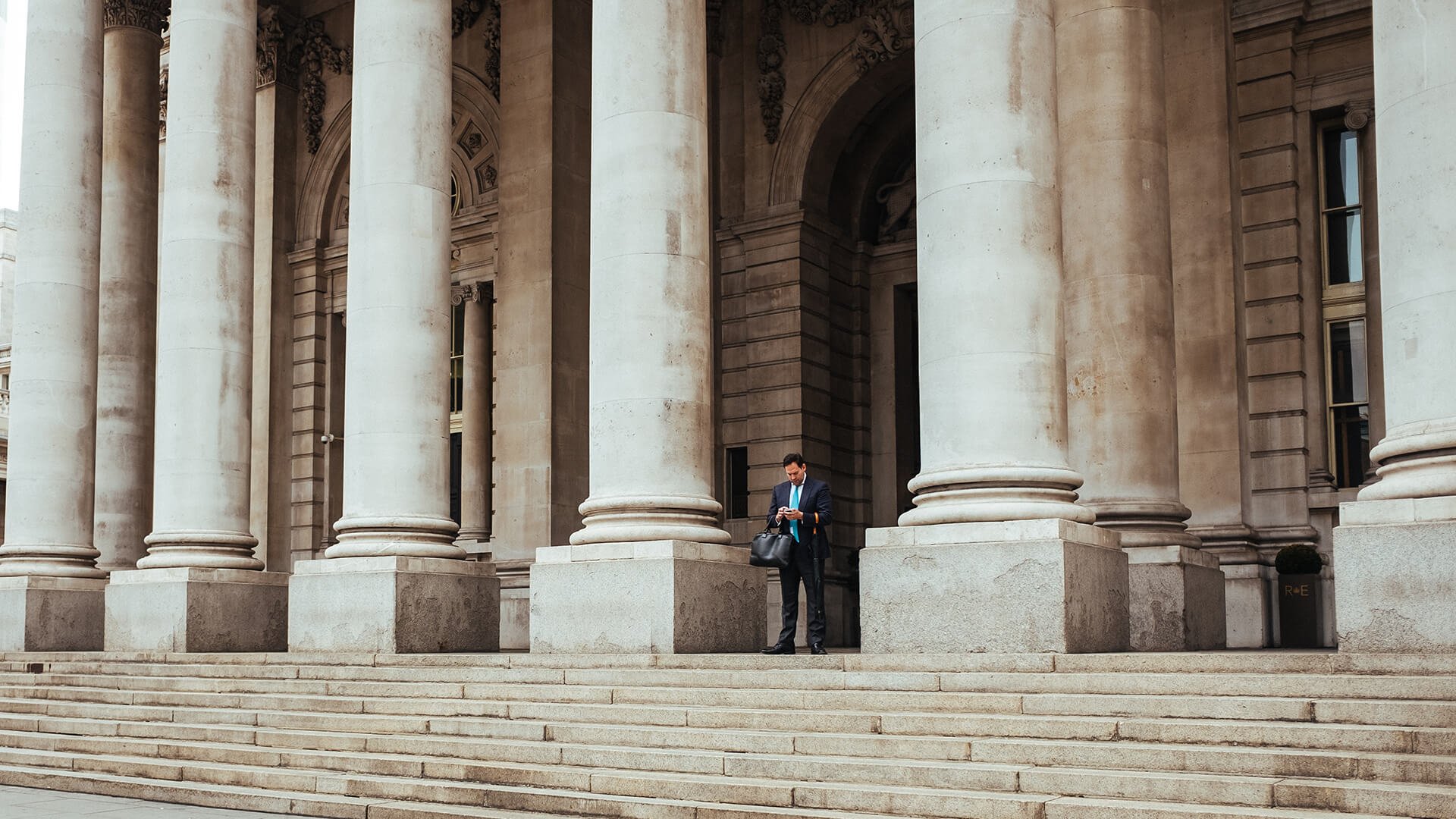 Man standing in front of a bank in London