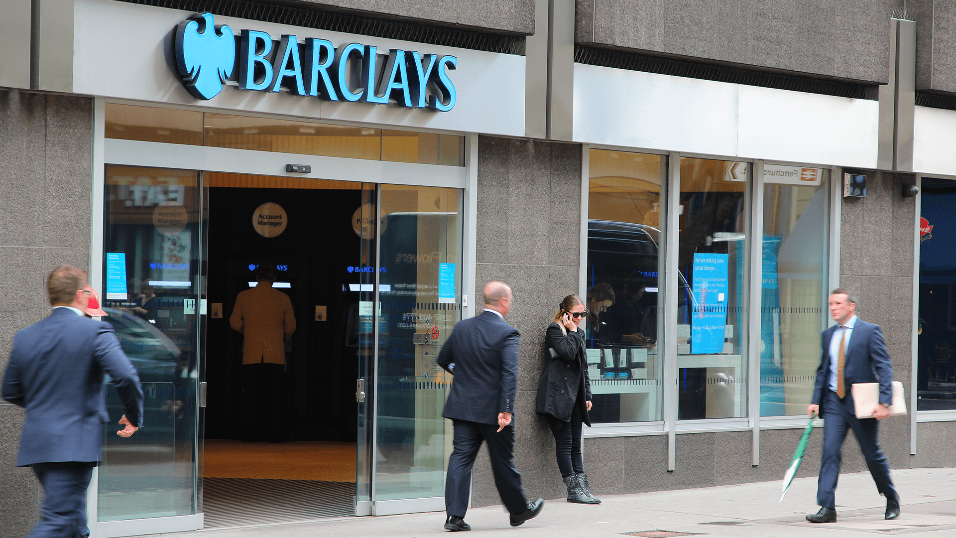 People walk by Barclays bank branch in London