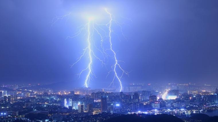 Investing in Operational Resilience illustrated by lightning striking near a city